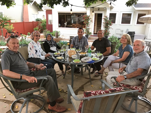 A group of Diplomacy Council members sit around a table at a home host dinner