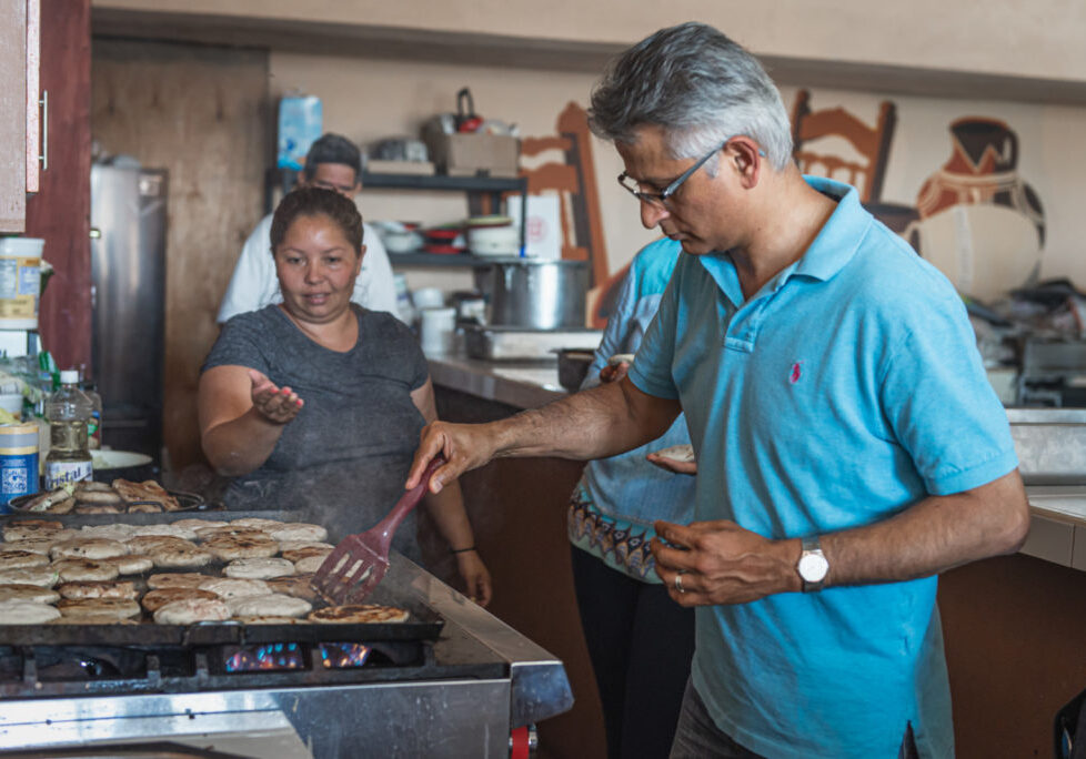 A man and a woman cook together in a kitchen during the Tijuana Gastro Diplomacy Tour.